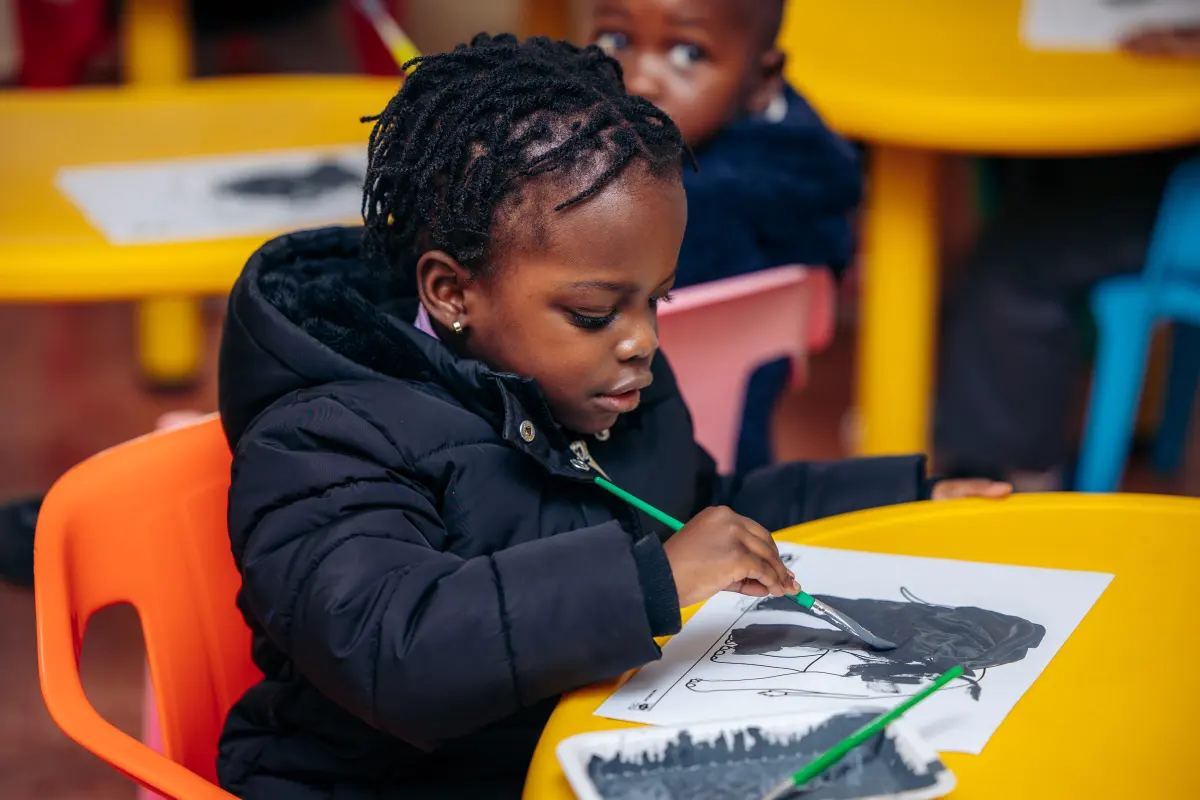 A teacher guiding an Early Years learner